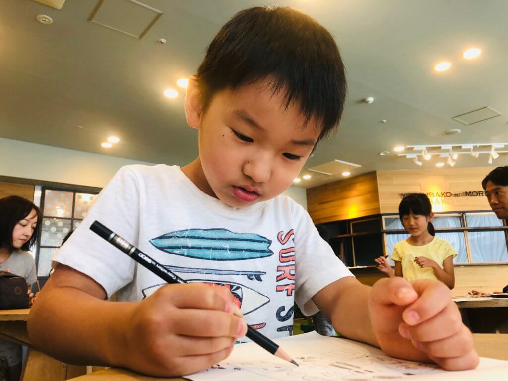 ワークショップで集中して絵を描く子ども